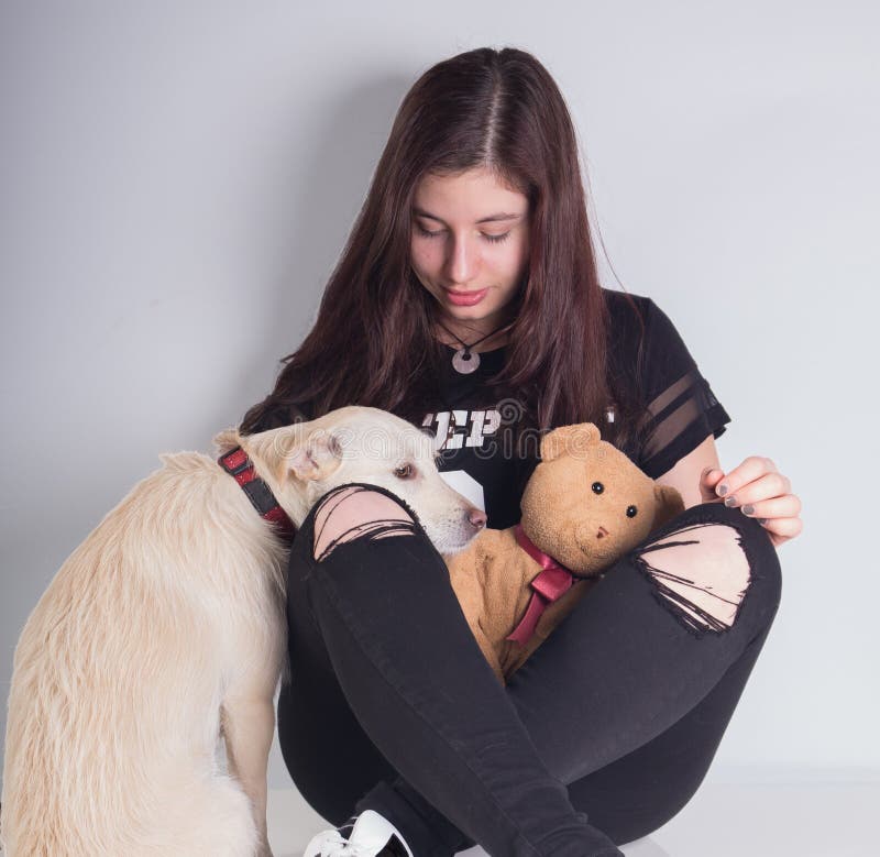 Bella ragazza con il cane di sguardo teddybear e triste immagine stock Bella ragazza con il cane di sguardo teddybear e triste immagine stock