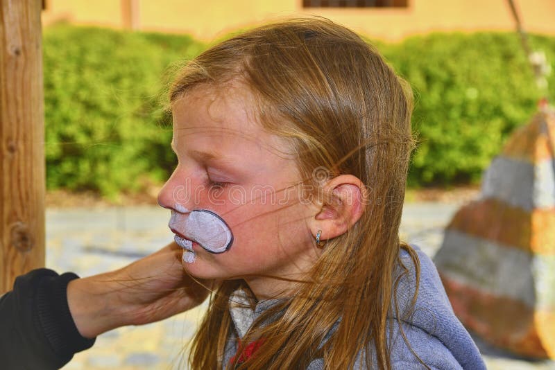 Bella ragazza con il fronte dipinto come un coniglio Pittura del fronte sul fronte del bambino immagini stock Bella ragazza con il fronte dipinto come un coniglio Pittura del fronte sul fronte del bambino immagini stock