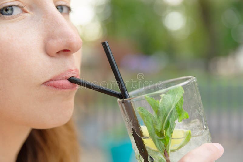 Bella ragazza con la bevanda del cocktail di mojito in ristorante all'aperto fotografia stock Bella ragazza con la bevanda del cocktail di mojito in ristorante all'aperto fotografia stock
