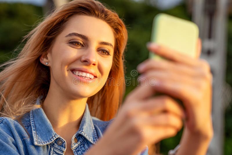 Bella ragazza di modo che fa selfie con il telefono al tramonto immagini stock libere da diritti Bella ragazza di modo che fa selfie con il telefono al tramonto immagini stock libere da diritti