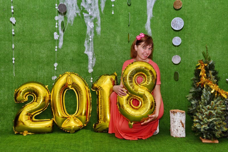 Beautiful pretty girl in dress wearing figure 8 next to the numbers of the new year 2018 Congratulations on the Christmas - concept. Beautiful pretty girl in dress wearing figure 8 next to the numbers of the new year 2018 Congratulations on the Christmas - concept