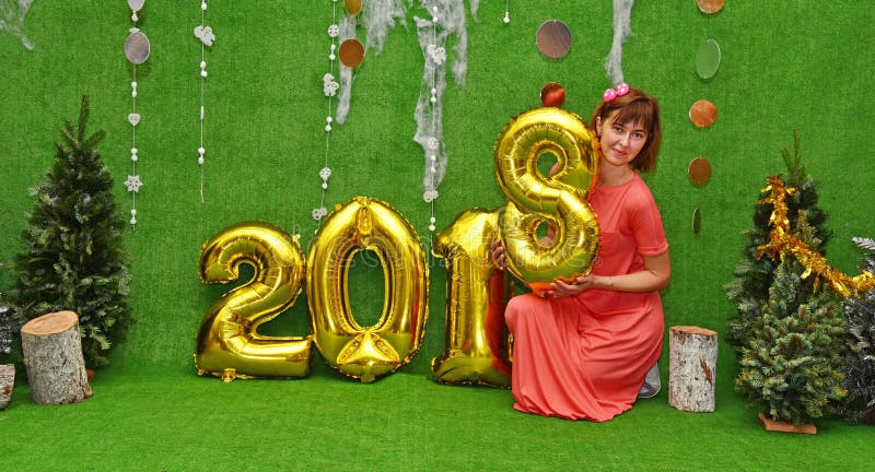 Beautiful pretty girl in dress wearing figure 8 next to the numbers of the new year 2018 Congratulations on the Christmas - concept. Beautiful pretty girl in dress wearing figure 8 next to the numbers of the new year 2018 Congratulations on the Christmas - concept