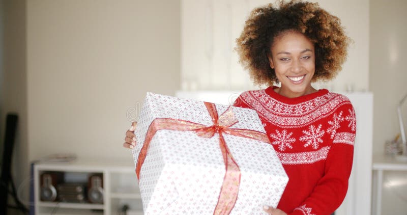 Bella ragazza sorpresa che sta con la grande scatola