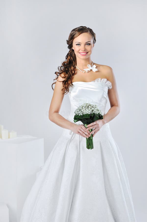 Bella ragazza sorridente in un vestito da sposa bianco fotografie stock Bella ragazza sorridente in un vestito da sposa bianco fotografie stock