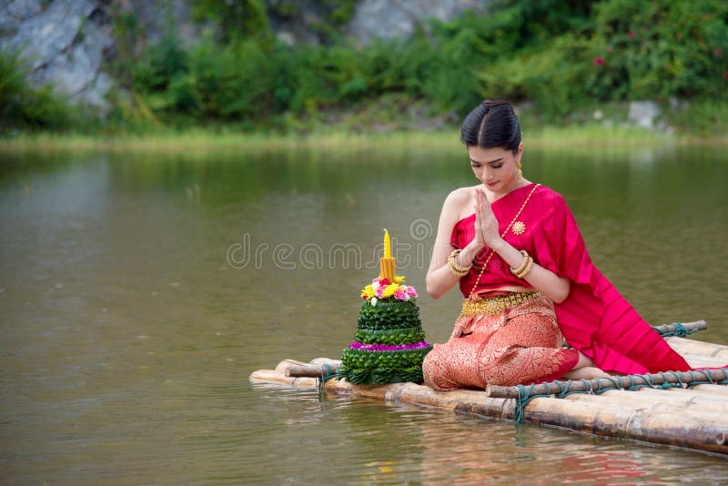 Bella ragazza tailandese che porta vestito tradizionale tailandese rosso nel festival di Loy Krathong fotografie stock Bella ragazza tailandese che porta vestito tradizionale tailandese rosso nel festival di Loy Krathong fotografie stock
