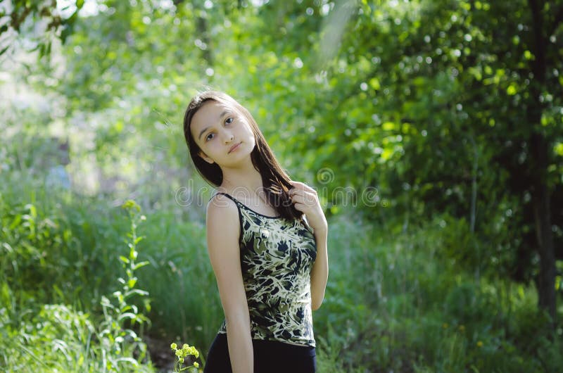 Bella ragazza teenager su un fondo verde dell'albero immagini stock libere da diritti Bella ragazza teenager su un fondo verde dell'albero immagini stock libere da diritti
