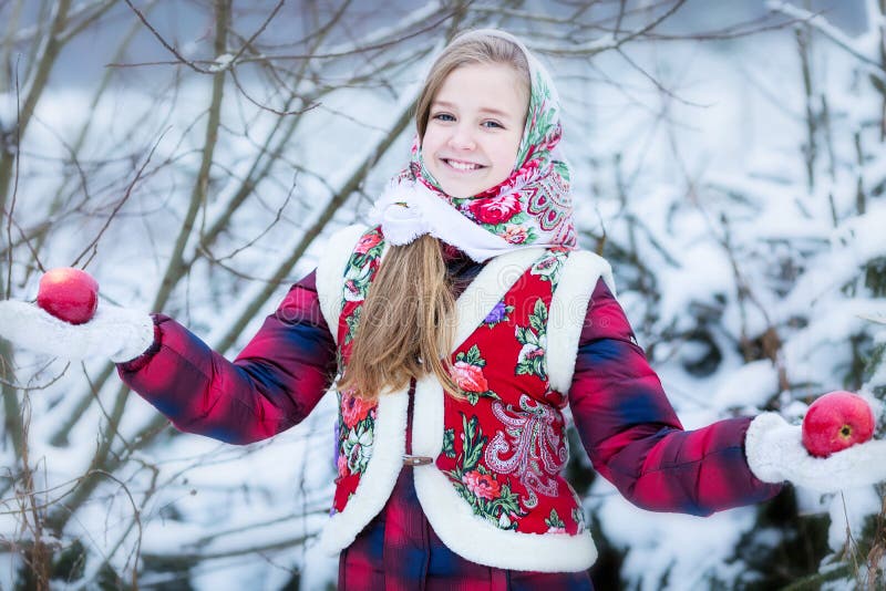 Bella ragazza teenager in vestiti nazionali russi con le mele rosse in mani di inverno immagine stock Bella ragazza teenager in vestiti nazionali russi con le mele rosse in mani di inverno immagine stock