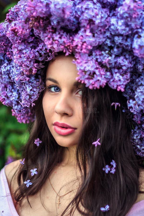 Bella ragazza in una corona del lillà fotografia stock libera da diritti Bella ragazza in una corona del lillà fotografia stock libera da diritti