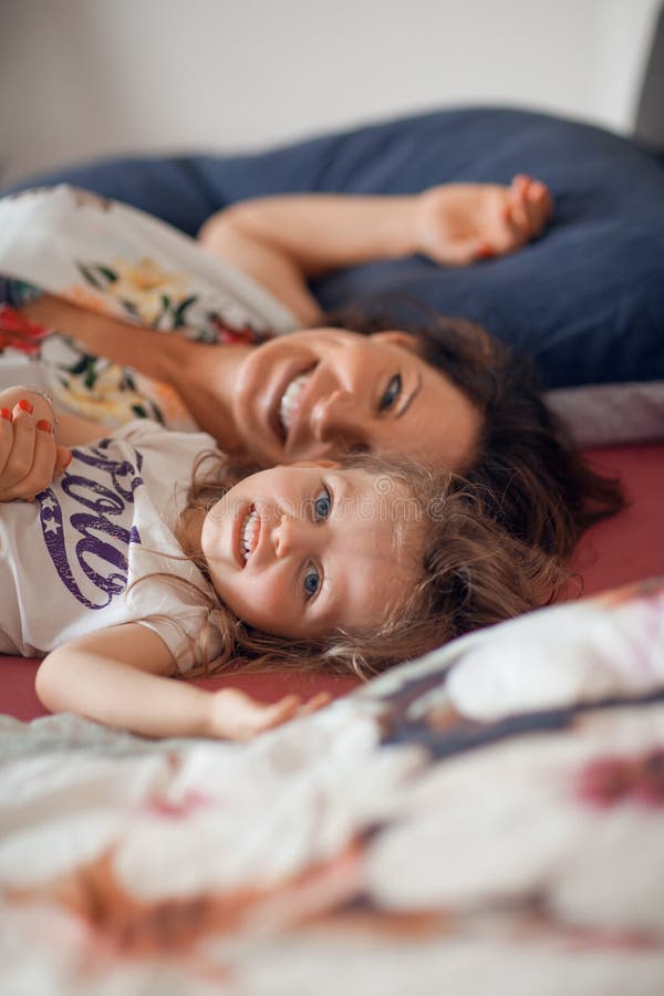 Bella scena felice della famiglia con la madre che parla con sua piccola figlia con la sua bambola fotografia stock Bella scena felice della famiglia con la madre che parla con sua piccola figlia con la sua bambola fotografia stock