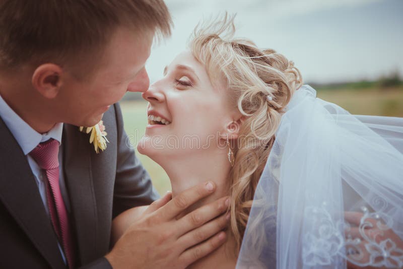 Bella sposa e sposo che si levano in piedi nell'erba e nel baciare Tiro di modo delle coppie di nozze immagini stock libere da diritti Bella sposa e sposo che si levano in piedi nell'erba e nel baciare Tiro di modo delle coppie di nozze immagini stock libere da diritti