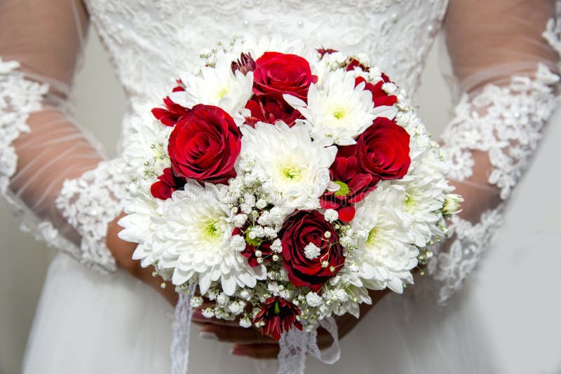 Bella sposa in un vestito da sposa che tiene un mazzo dei tulipani rossi Priorità bassa bianca fotografia stock libera da diritti Bella sposa in un vestito da sposa che tiene un mazzo dei tulipani rossi Priorità bassa bianca fotografia stock libera da diritti