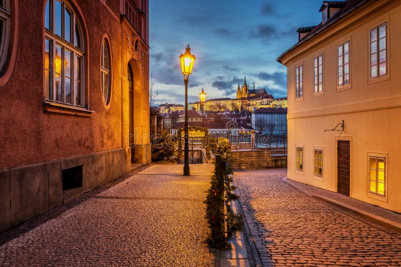 Bella vista del castello di Praga al tramonto da una via storica con le lampade di gas sopra il fiume la Moldava fotografia stock libera da diritti Bella vista del castello di Praga al tramonto da una via storica con le lampade di gas sopra il fiume la Moldava fotografia stock libera da diritti
