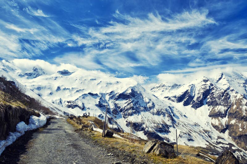 Beautiful view of Alps mountains. Spring in National Park Hohe Tauern, Austria. Green valley and snowy mountains peaks. Grossglockner high alpine road. Beautiful view of Alps mountains. Spring in National Park Hohe Tauern, Austria. Green valley and snowy mountains peaks. Grossglockner high alpine road.