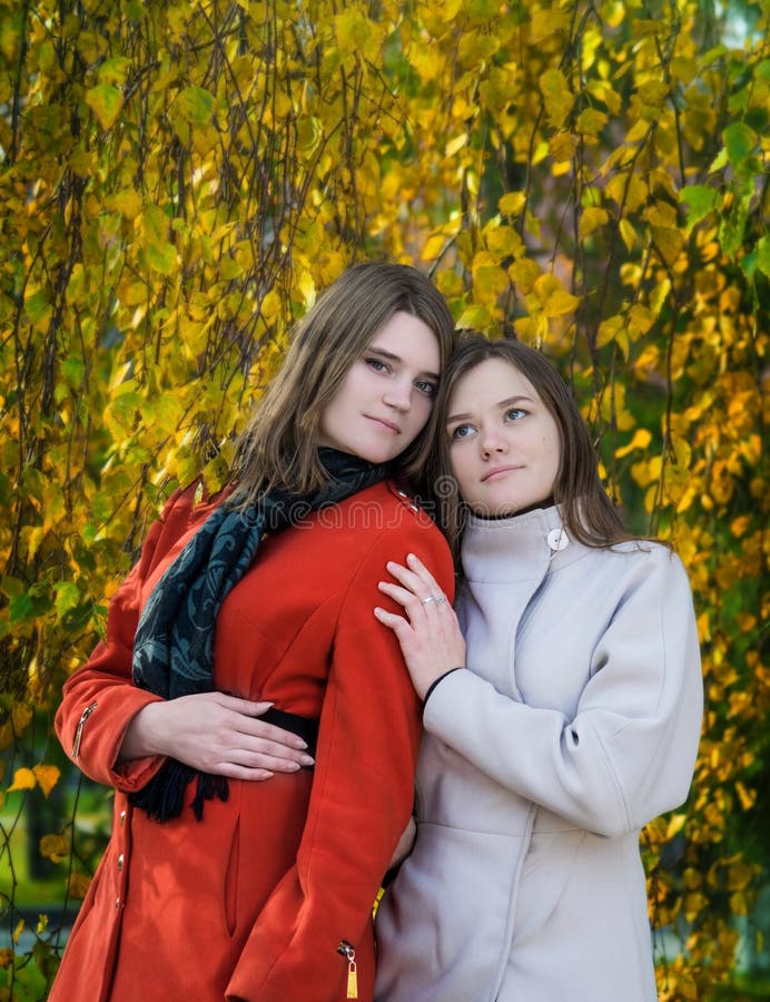 Belle amiche felici del ritratto due un giorno soleggiato di autunno immagini stock Belle amiche felici del ritratto due un giorno soleggiato di autunno immagini stock