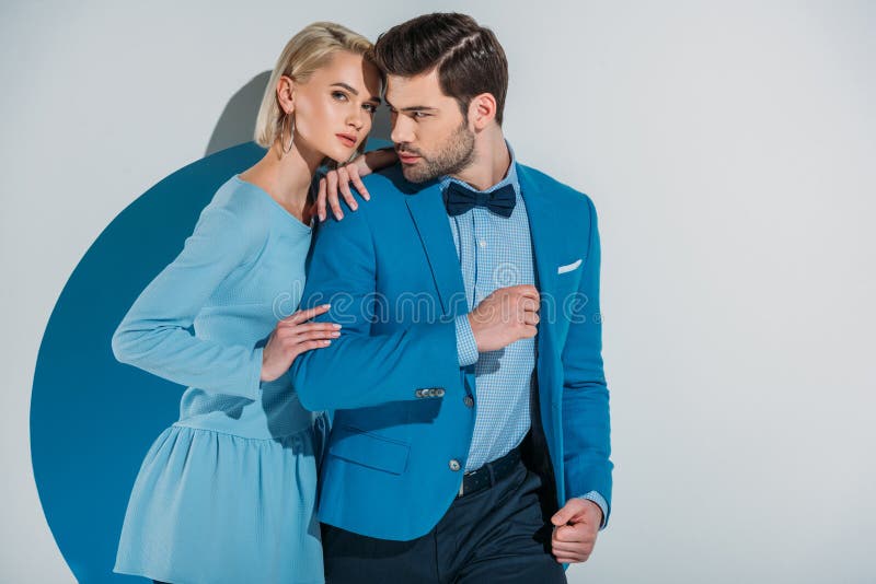 belle coppie in vestito blu alla moda e vestito che sta insieme nell'apertura fotografia stock belle coppie in vestito blu alla moda e vestito che sta insieme nell'apertura fotografia stock