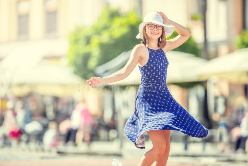 Belle danse mignonne de jeune fille sur la rue du bonheur La fille heureuse mignonne en été vêtx la danse au soleil photographie stock Belle danse mignonne de jeune fille sur la rue du bonheur La fille heureuse mignonne en été vêtx la danse au soleil photographie stock