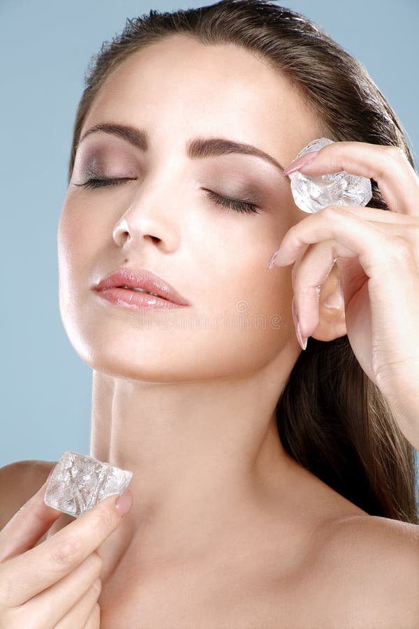Belle femme appliquant le traitement de glaçon sur le visage photos libres de droits Belle femme appliquant le traitement de glaçon sur le visage photos libres de droits