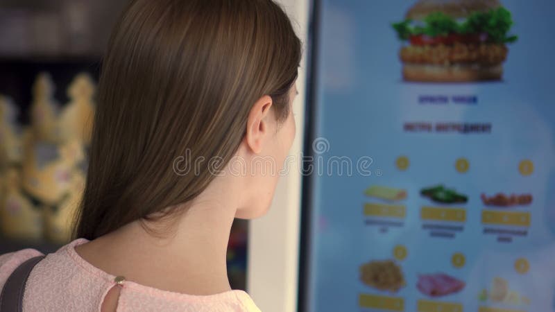 Belle femme attirante dans le mail Nourriture de commande par l'intermédiaire de machine de libre service au restaurant de chaîne banque de vidéos Belle femme attirante dans le mail Nourriture de commande par l'intermédiaire de machine de libre service au restaurant de chaîne banque de vidéos