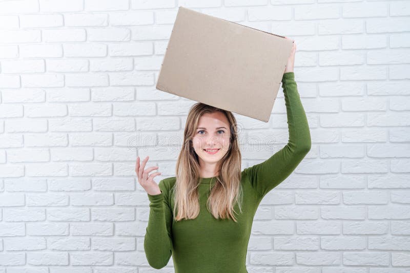 Belle femme avec boîte de colis sur sa tête. livraison d'un colis images stock