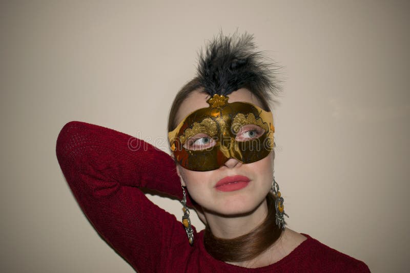 Belle femme avec le maquillage dramatique et rouge à lèvres rouge dans un masque jaune photos stock Belle femme avec le maquillage dramatique et rouge à lèvres rouge dans un masque jaune photos stock