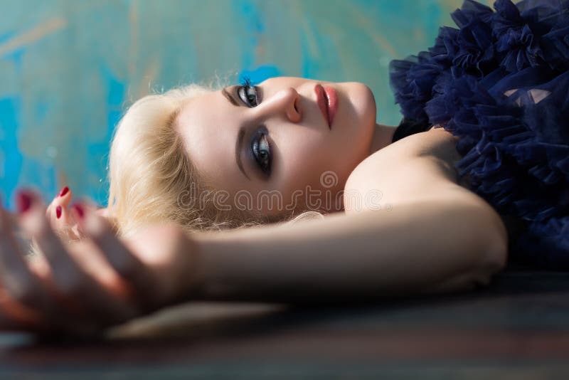 Belle femme blonde adulte s'étendant sur le plancher photographie stock Belle femme blonde adulte s'étendant sur le plancher photographie stock