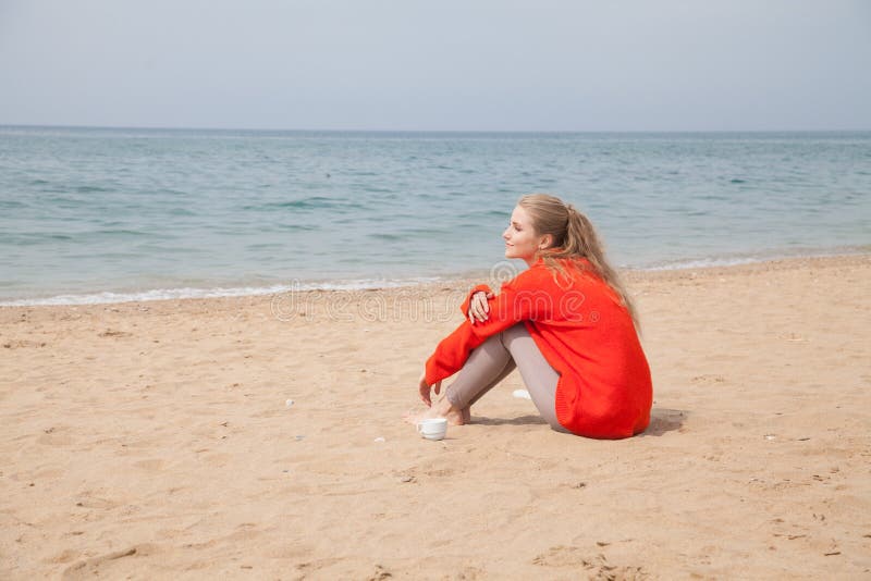 Belle Femme Blonde Assise Seule Sur La Plage Au Bord De La Mer Image