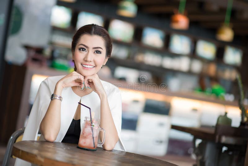 Belle femme buvant la boisson douce en café photo stock Belle femme buvant la boisson douce en café photo stock