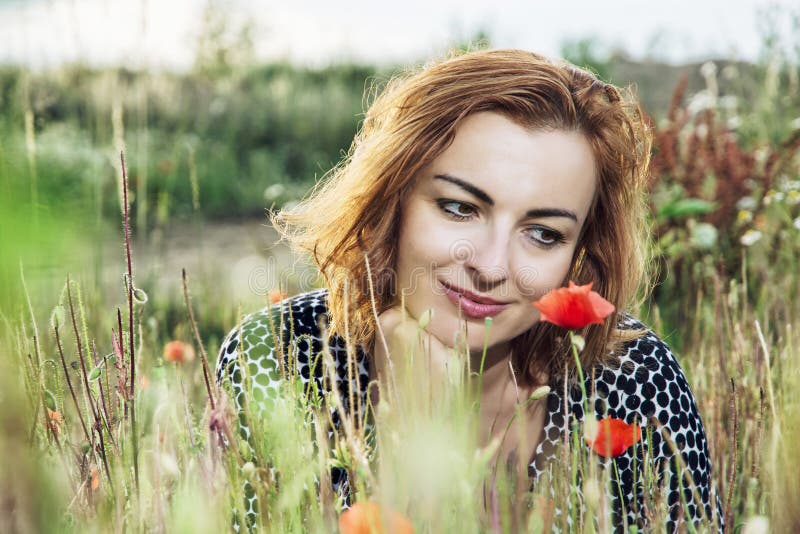 Belle femme caucasienne posant avec le gisement de fleurs de pavot, summe images libres de droits Belle femme caucasienne posant avec le gisement de fleurs de pavot, summe images libres de droits