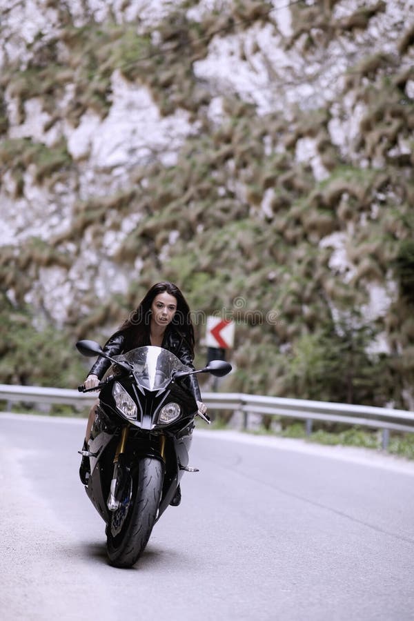 Belle femme conduisant une moto photo libre de droits Belle femme conduisant une moto photo libre de droits