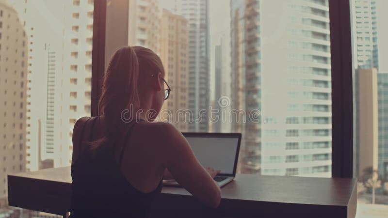 Belle femme d'affaires réussie travaillant sur un ordinateur portable dans son bureau avec la fenêtre vue paysage urbain. Fort ind banque de vidéos