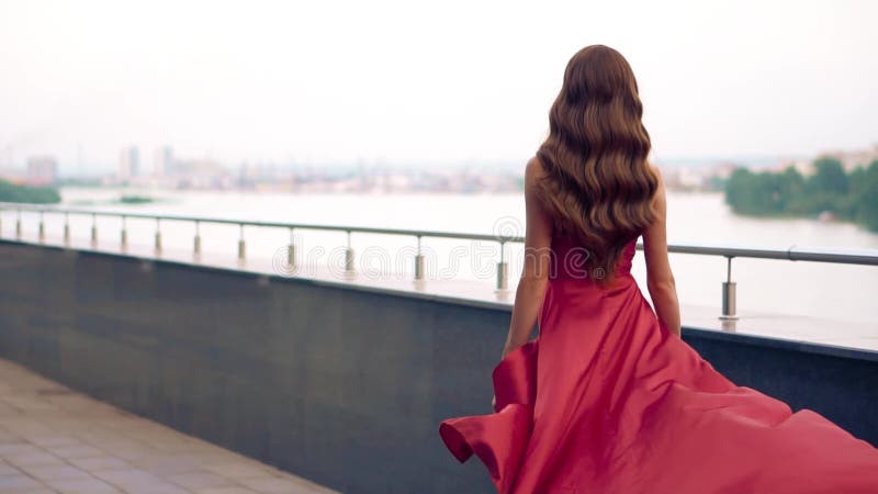 Belle femme dans la robe de flottement rouge banque de vidéos