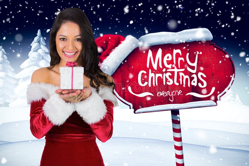 Belle femme dans le costume de Santa tenant le cadeau de Noël image stock Belle femme dans le costume de Santa tenant le cadeau de Noël image stock