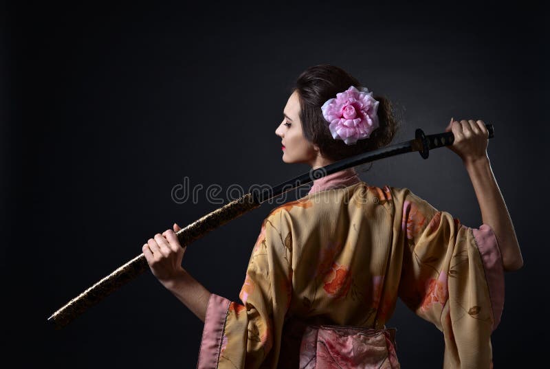 Belle femme dans le kimono japonais traditionnel avec le katana photo stock Belle femme dans le kimono japonais traditionnel avec le katana photo stock