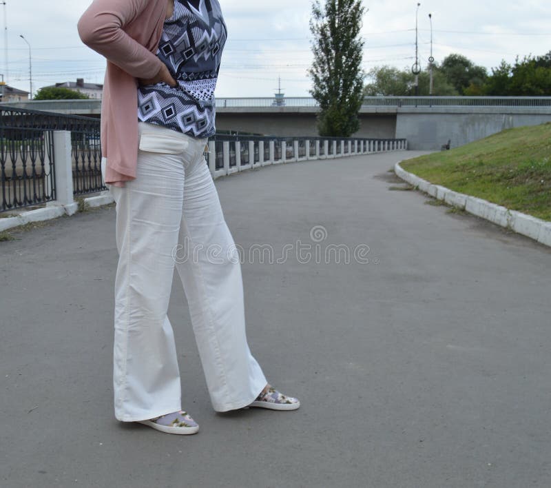 Belle femme dans le pantalon blanc posant pendant l'été photos stock Belle femme dans le pantalon blanc posant pendant l'été photos stock