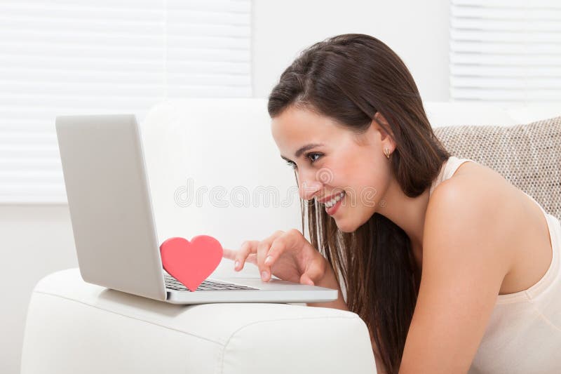 Belle femme datant en ligne sur l'ordinateur portable photos stock Belle femme datant en ligne sur l'ordinateur portable photos stock