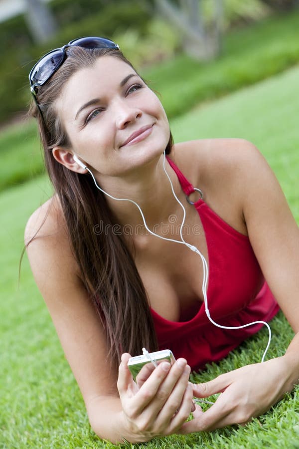 Belle femme de Brunette écoutant le joueur MP3 photographie stock libre de droits Belle femme de Brunette écoutant le joueur MP3 photographie stock libre de droits