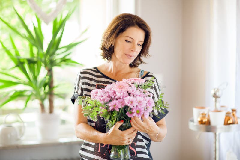 Belle femme de Moyen Âge décorant à la maison des fleurs images libres de droits