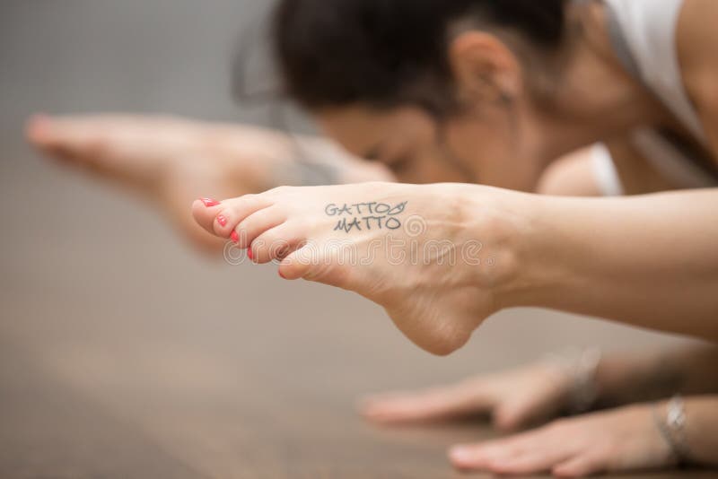 Belle femme de yogi avec le tatouage sur sa jambe photo libre de droits Belle femme de yogi avec le tatouage sur sa jambe photo libre de droits