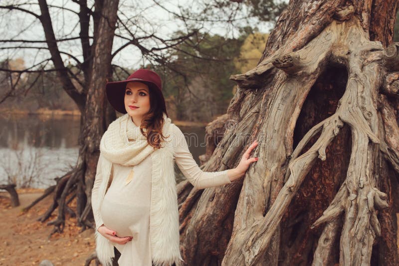 Belle femme enceinte dans le chapeau de mode sur la promenade extérieure chaude confortable photographie stock Belle femme enceinte dans le chapeau de mode sur la promenade extérieure chaude confortable photographie stock