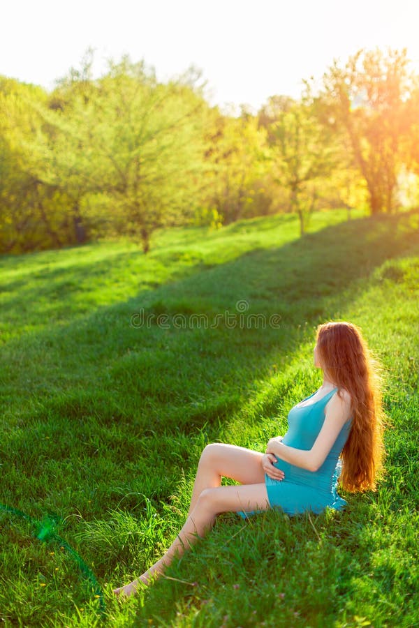 Belle femme enceinte dans le jardin coucher du soleil ou lever de soleil photos libres de droits Belle femme enceinte dans le jardin coucher du soleil ou lever de soleil photos libres de droits