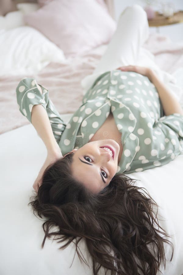 Belle femme enceinte posant tout en se trouvant sur un lit à la maison photo libre de droits Belle femme enceinte posant tout en se trouvant sur un lit à la maison photo libre de droits