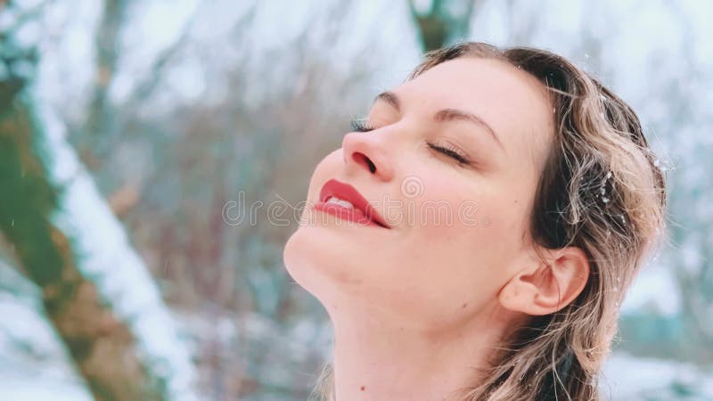Belle femme heureuse aime la nature hivernale souriant visage joyeux sous la neige banque de vidéos