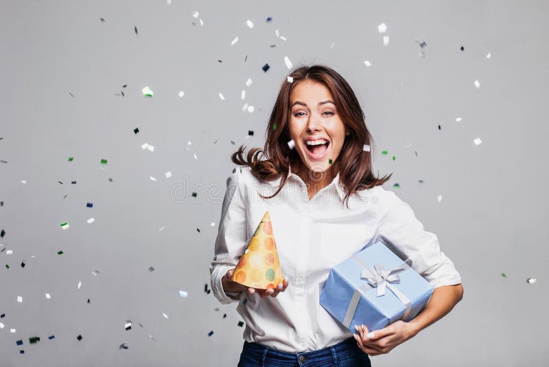 Belle femme heureuse à la partie de célébration avec des confettis tombant partout sur elle Anniversaire ou soirée du Nouveau an photo libre de droits Belle femme heureuse à la partie de célébration avec des confettis tombant partout sur elle Anniversaire ou soirée du Nouveau an photo libre de droits