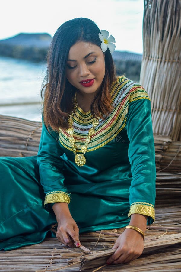 Belle femme maldivienne dans la robe nationale faisant des plats à partir des palmettes sèches images libres de droits Belle femme maldivienne dans la robe nationale faisant des plats à partir des palmettes sèches images libres de droits