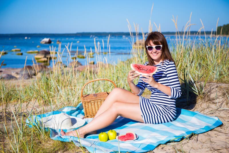 Belle femme mangeant la pastèque sur la plage images stock Belle femme mangeant la pastèque sur la plage images stock