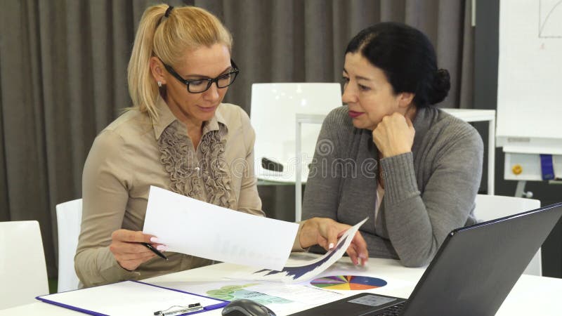 Belle femme mûre et son colelague supérieur d'affaires sur une réunion photo stock Belle femme mûre et son colelague supérieur d'affaires sur une réunion photo stock