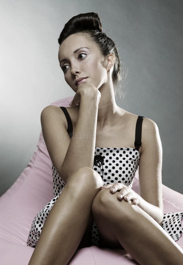 Belle femme pensive s'asseyant sur la présidence photographie stock Belle femme pensive s'asseyant sur la présidence photographie stock