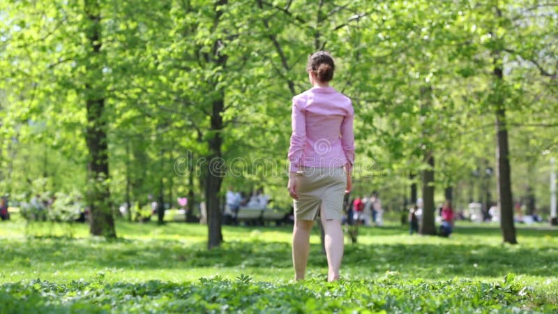 Belle femme pieds nus marcher dans le parc au printemps clips vidéos