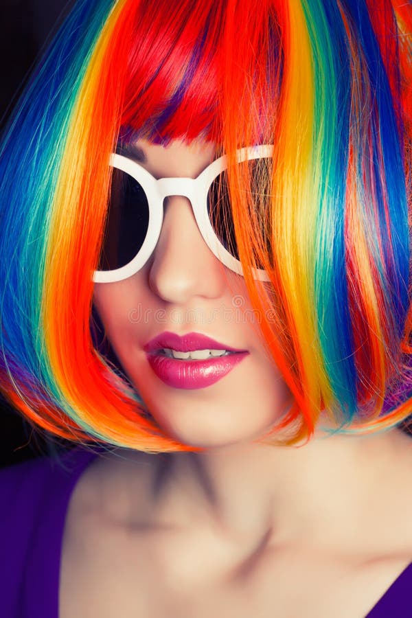 Belle femme portant la perruque colorée et les agains blancs de lunettes de soleil photo stock Belle femme portant la perruque colorée et les agains blancs de lunettes de soleil photo stock