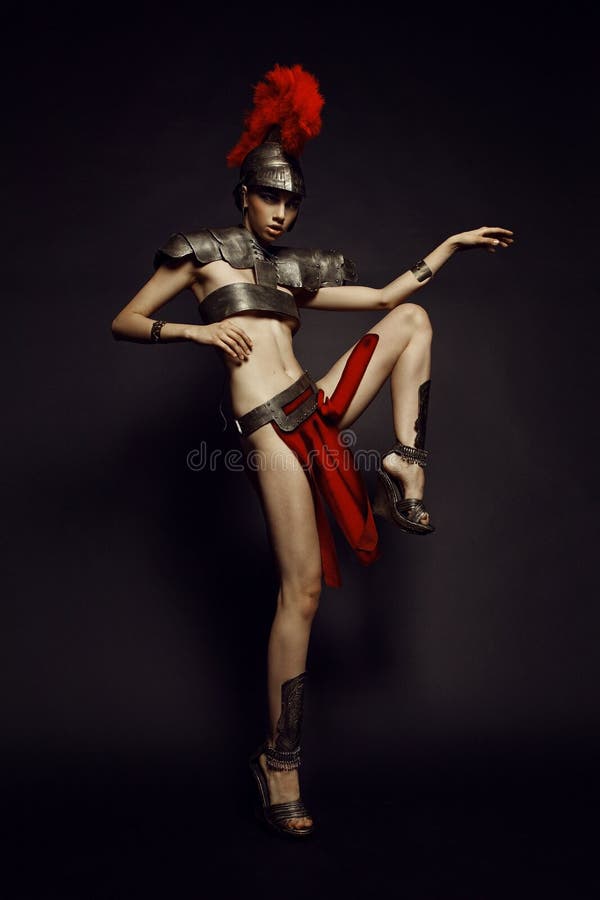 Belle femme romaine dans l'armure et le casque photo stock Belle femme romaine dans l'armure et le casque photo stock